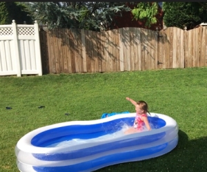 Girl splashing into paddling pool