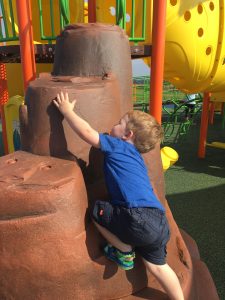 Boy climbing on 'rocks' at playground
